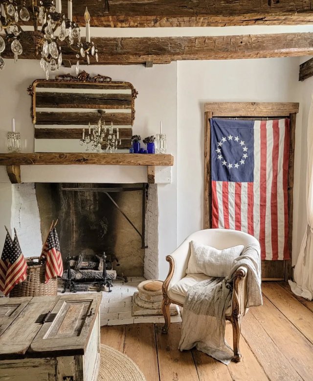 A cozy room blending rustic charm with patriotic pride, featuring a Betsy Ross flag and elegant chandeliers. Photo by Anonymous